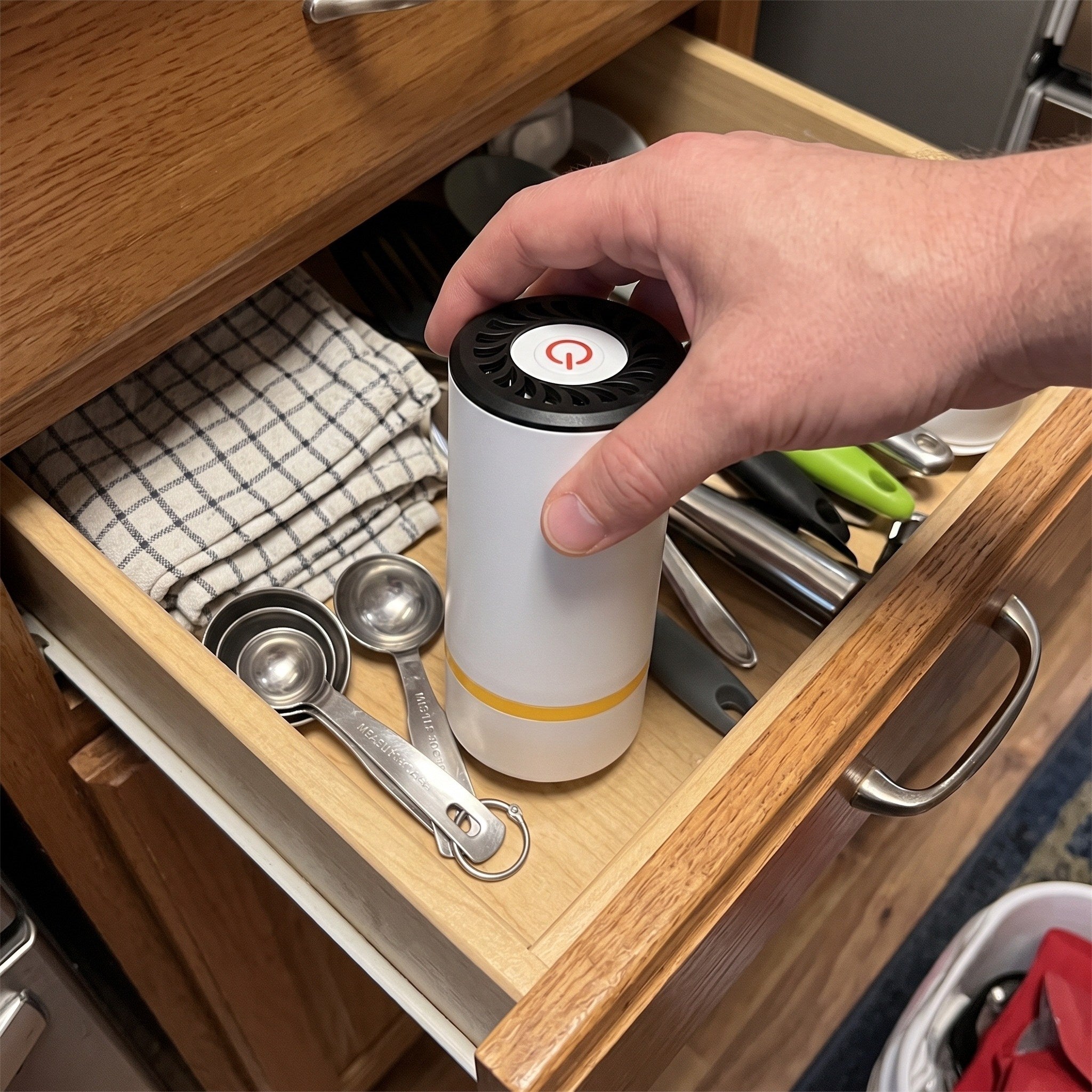 Hand placing Keepwell in a kitchen drawer